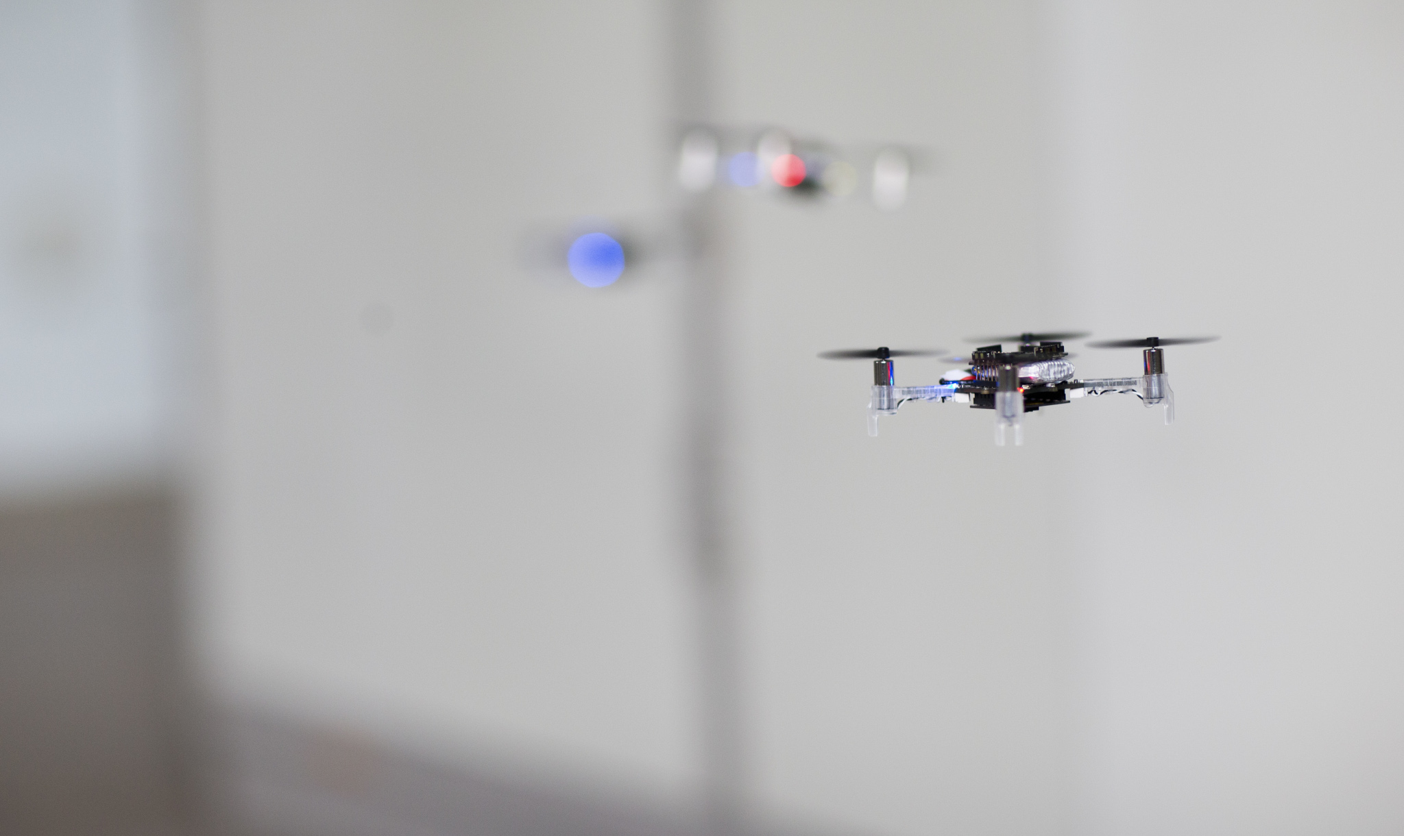A swarm of tiny drones autonomously explores an unknown environment.